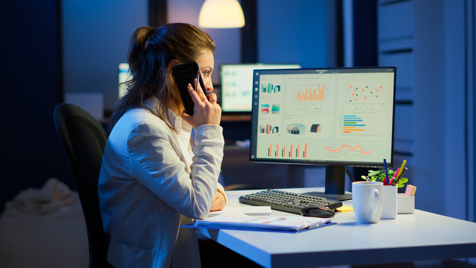 nervous-manager-discussing-smartphone-with-employee-working-overtime-sitting-desk-business-office-late-night-resolving-financial-problems-busy-employee-using-modern-technology-network